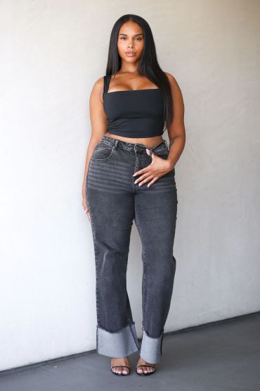Woman in black crop top and cuffed jeans.