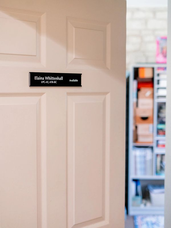 Open door leading to a creative office with the practitioner's name on the door 