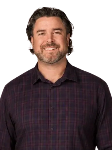 Smiling man with beard in a dark plaid shirt.