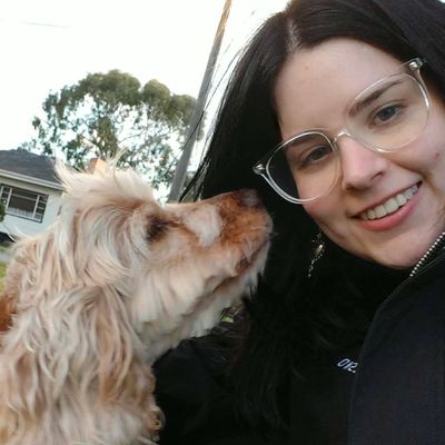 Dog and smiling woman with glasses.