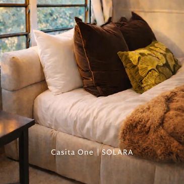 Cozy sofa with multiple cushions and a throw blanket.