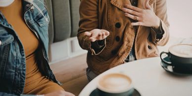 Two people engaged in a conversation over coffee.