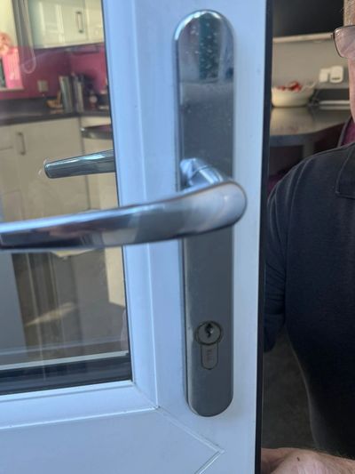Close-up of a door handle and lock on a white door.
