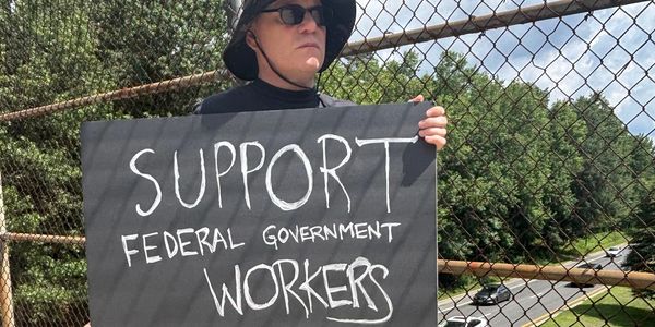 Jonathan White at protest, with sign that reads "Support Federal Government Workers"
