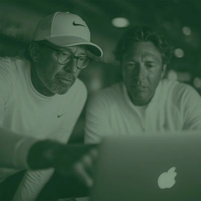 Two men intently looking at a laptop screen.