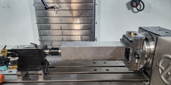 Metal block securely held in a machine vise for machining.