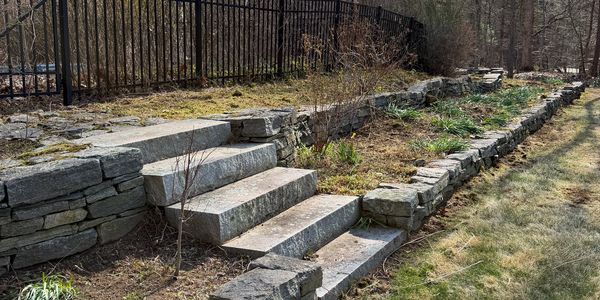 Stone steps and retaining wall in a garden area.