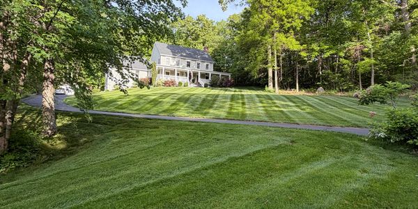 Large white house with a freshly mowed lawn.