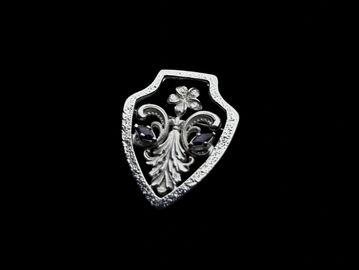 Ornate shield-shaped pendant with floral design.