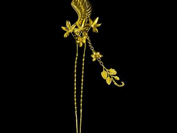 Elegant golden hairpin with floral and leaf design.