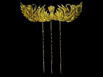 Intricate golden hairpin with three prongs and decorative motifs.