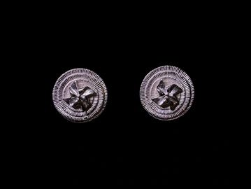 Close-up of two silver screws against black background.