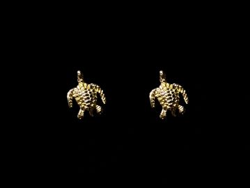 Pair of gold turtle-shaped earrings on black background.