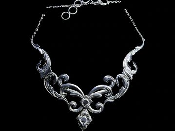 Elegant silver necklace with intricate floral design.