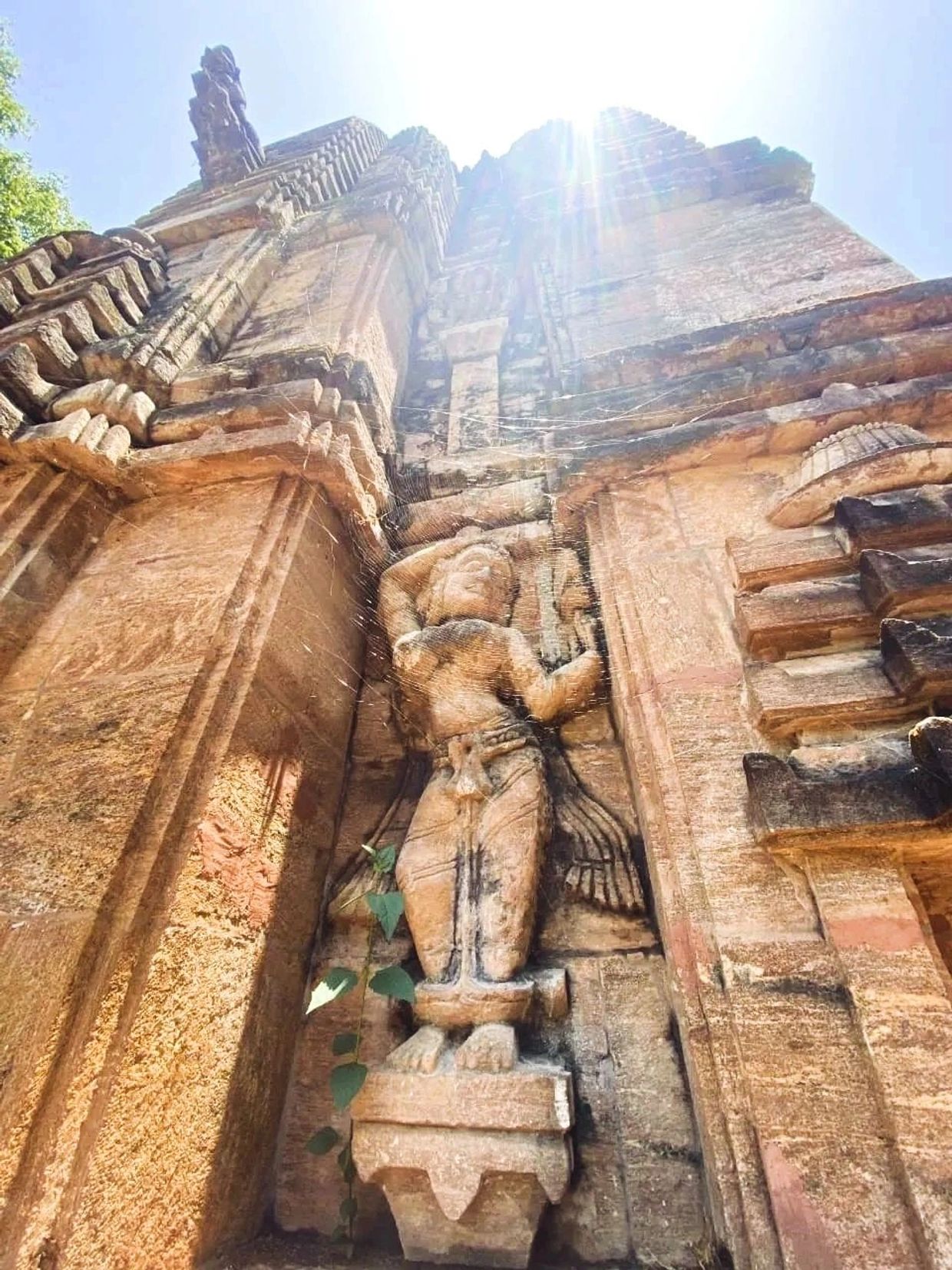 Ancient stone sculpture on a temple wall illuminated by sunlight.