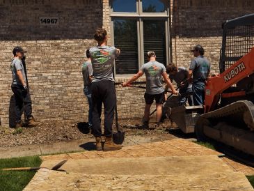 Workers discussing a project outside a brick building.