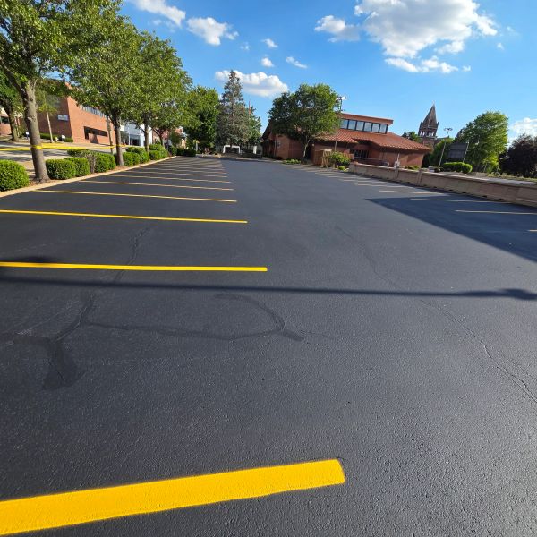 Empty parking lot with freshly painted lines under a bright blue sky.
