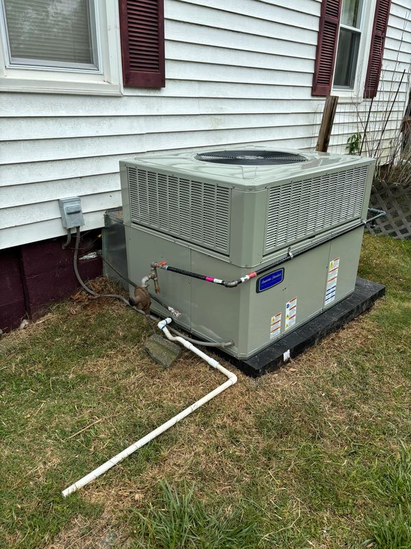 Large outdoor HVAC unit installed beside a house with white siding.