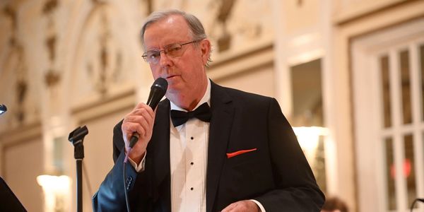 Closeup of a man on black suit is singing 