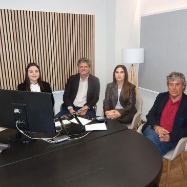 Four people sitting around a table in a modern office setting.