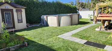 Above ground pool in a backyard with green lawn and patio.