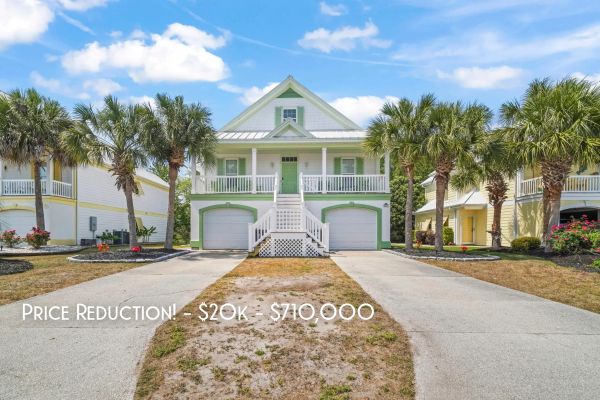 Beach-style house with palm trees and price reduction.