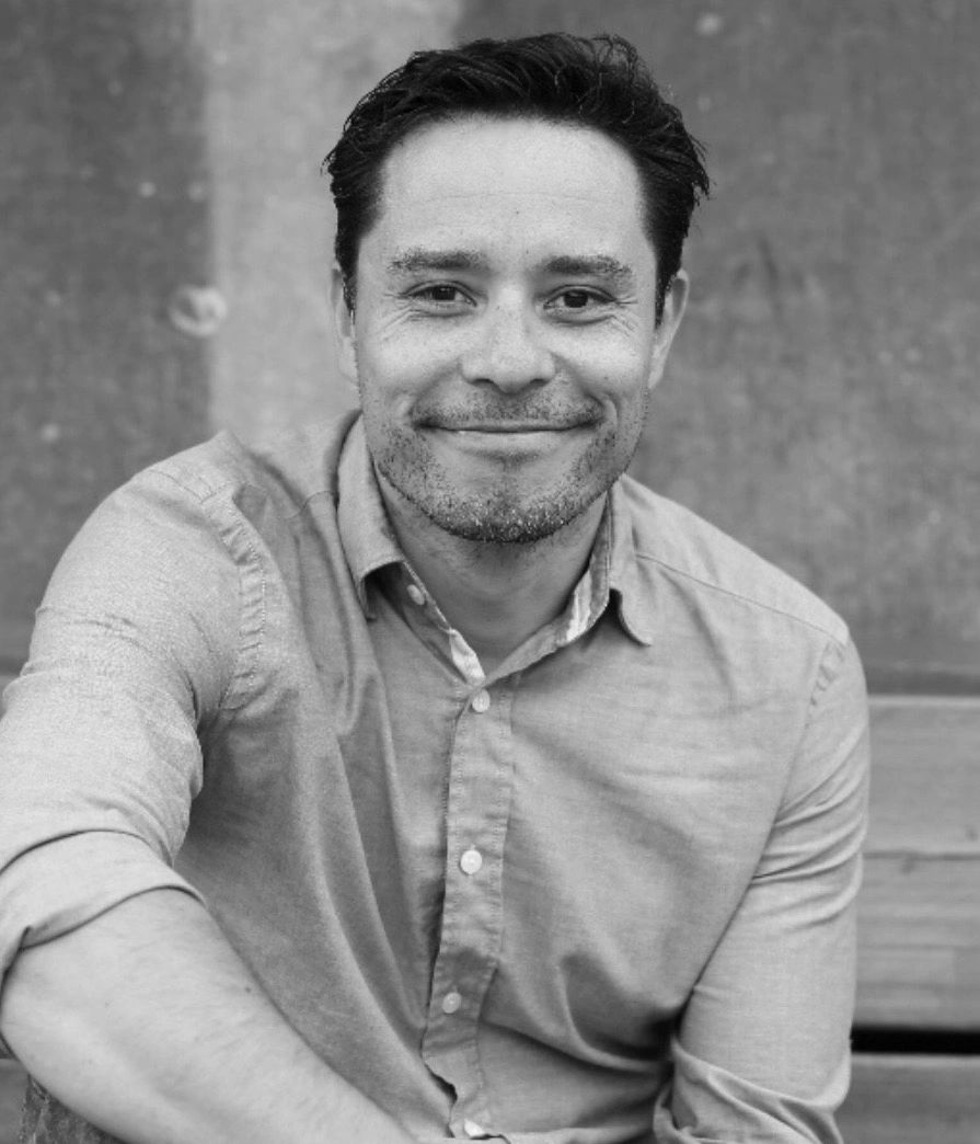 Mindfulness & Meditation Coach sitting in Amsterdam wearing a blue shirt and smiling