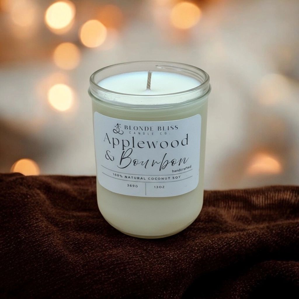 A handcrafted Applewood & Bourbon scented candle in a glass jar.