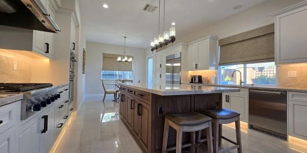 Modern kitchen with wooden island and white cabinets.
