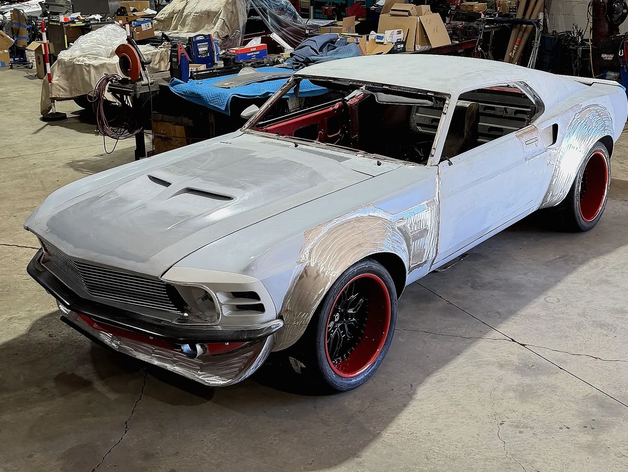 Classic muscle car undergoing restoration in a workshop.