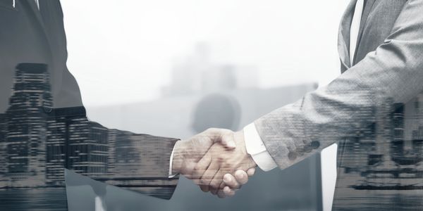 Two businessmen shaking hands, symbolizing partnership and agreement.