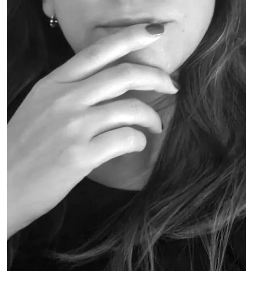 Close-up of a thoughtful person touching their lips with fingers.