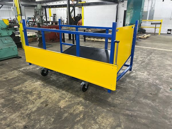 A blue and yellow industrial cart with wheels in a workshop.