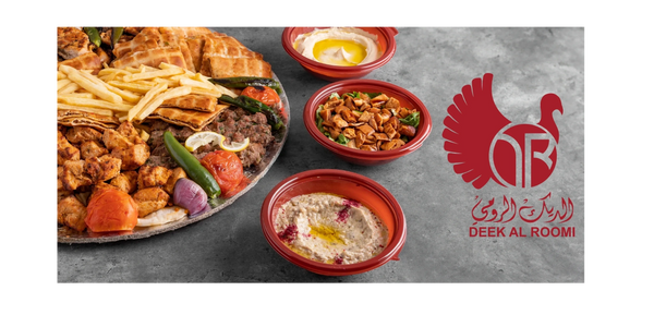 A large platter with grilled meats, fries, and sides, alongside three bowls of dips, showcasing Middle Eastern cuisine.