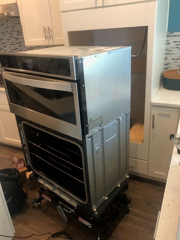 Oven unit on a dolly in a kitchen for installation.