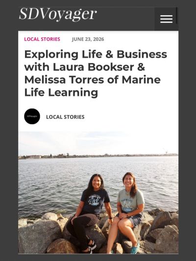 Laura Bookser & Melissa Torres of Marine Life Learning sit on large rocks overlooking the San Diego 