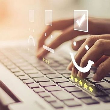 hands typing on a laptop with overlayed image of a tick, smiley  face and five stars 