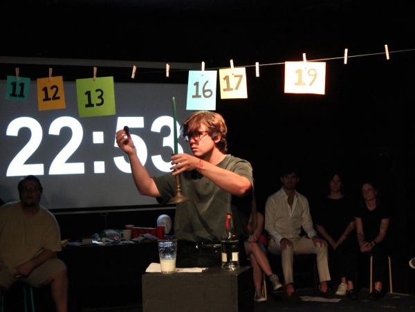 Person lighting a candle in front of a countdown clock.