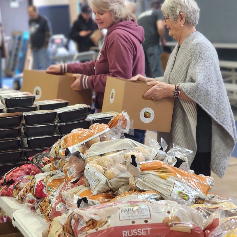 Volunteers packing food boxes at a community food distribution event.