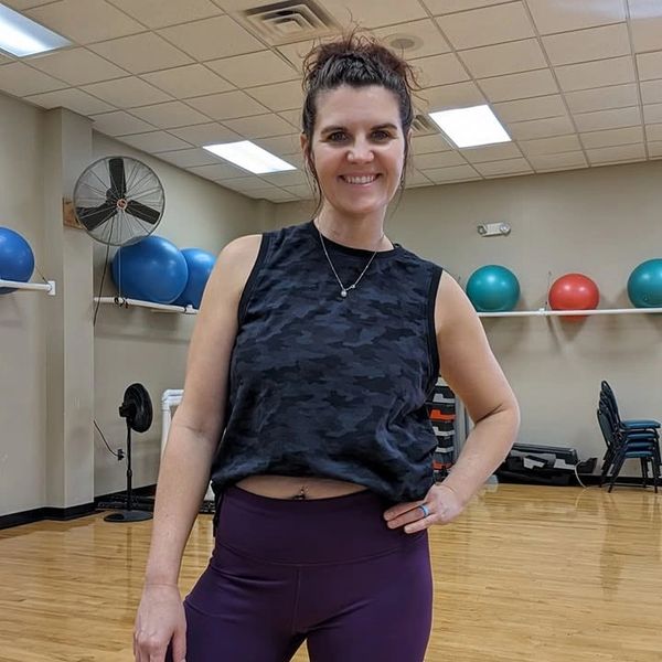 Smiling woman in workout clothes in gym.
