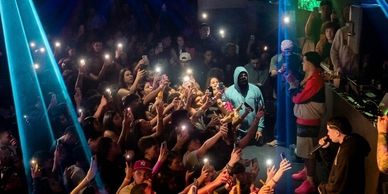 Crowd enjoying a live music performance with phones lit up.