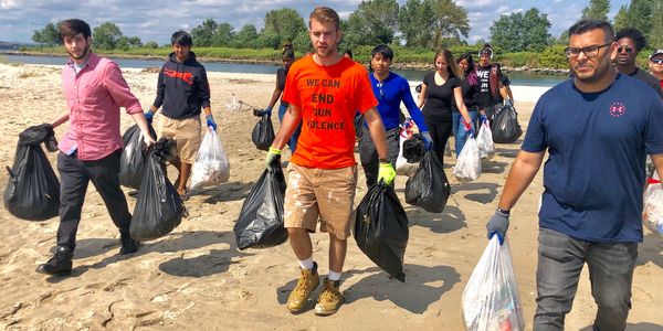 Group of volunteers cleaning up a beach.