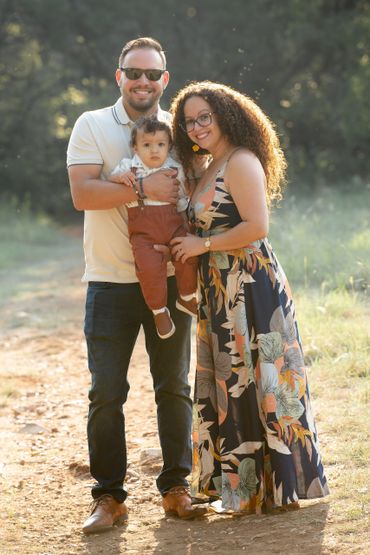 Family holds son during an outdoor family photography mini session in Austin, Texas. 