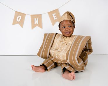 Boy smiles during his first birthday photo shoot in Austin, Texas cake smash photography studio. 