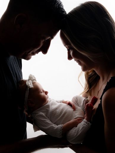 Couple embrace during a newborn photoshoot with an Austin, baby photographer. 