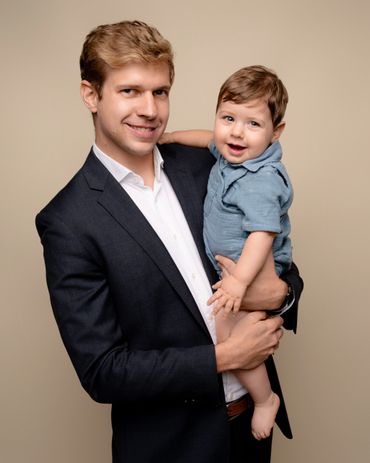 Dad poses holding son during his studio photography session in Austin, Texas