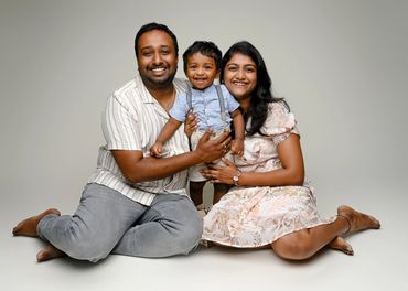 Family sits on the floor during a cake smash photoshoot in Austin, Tesas. 