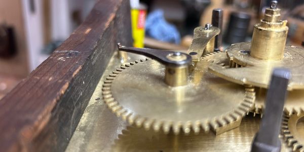 Wheels from a lantern clock are displayed on a work bench