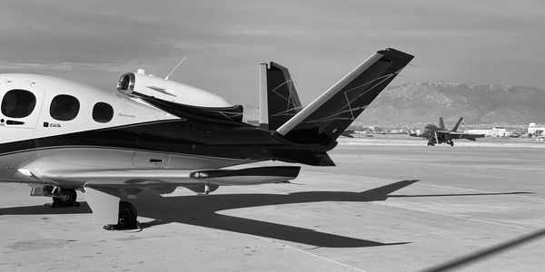 SF50 "Vision Jet" in Albuquerque, New Mexico situated in front of an F18 fighter jet.