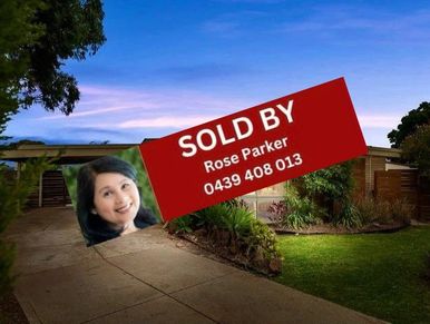 House with sold sign by Rose Parker at sunset.